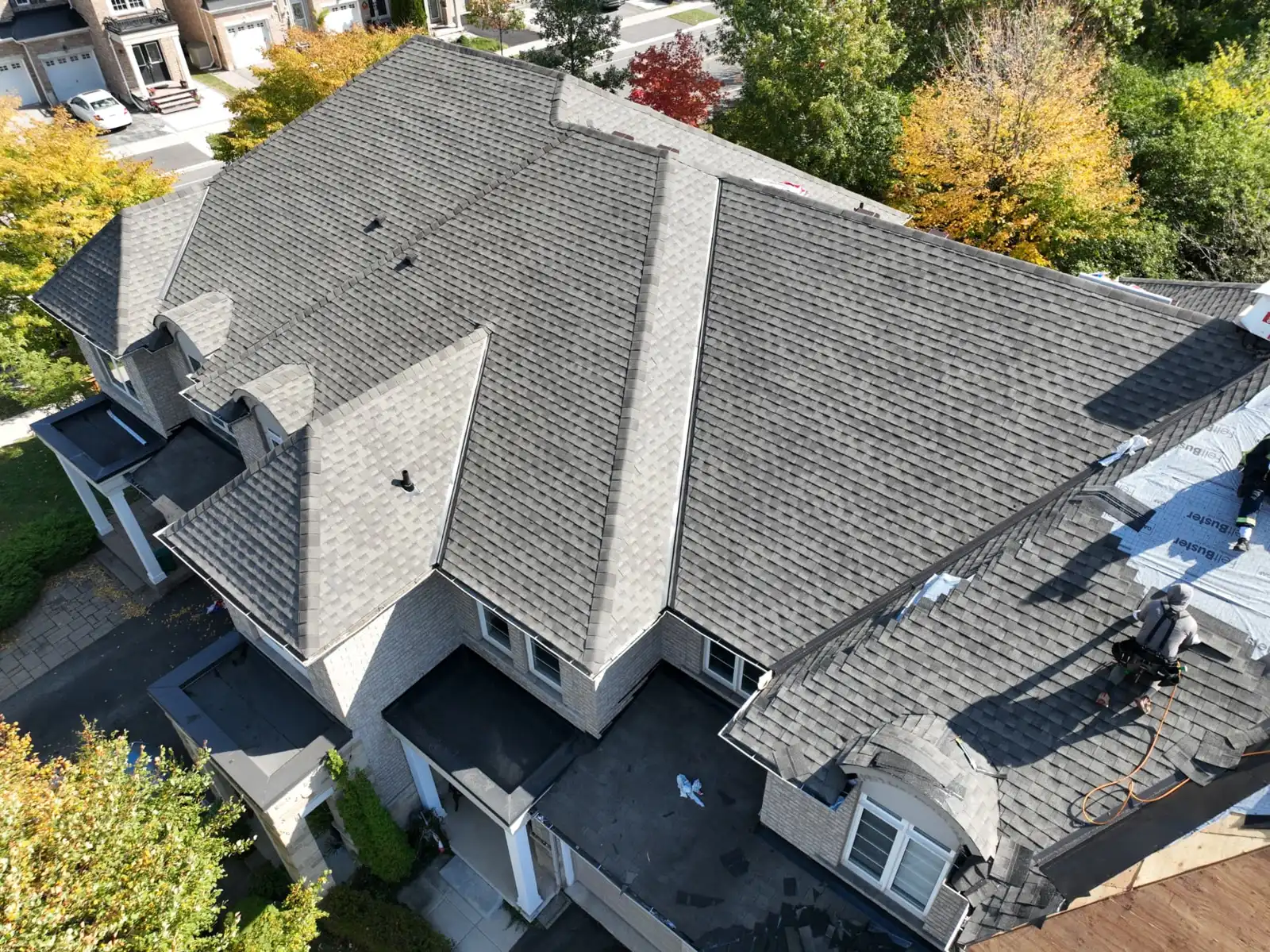 Completed Oakville grey shingle roof with intersecting ridges and dormers, viewed from above