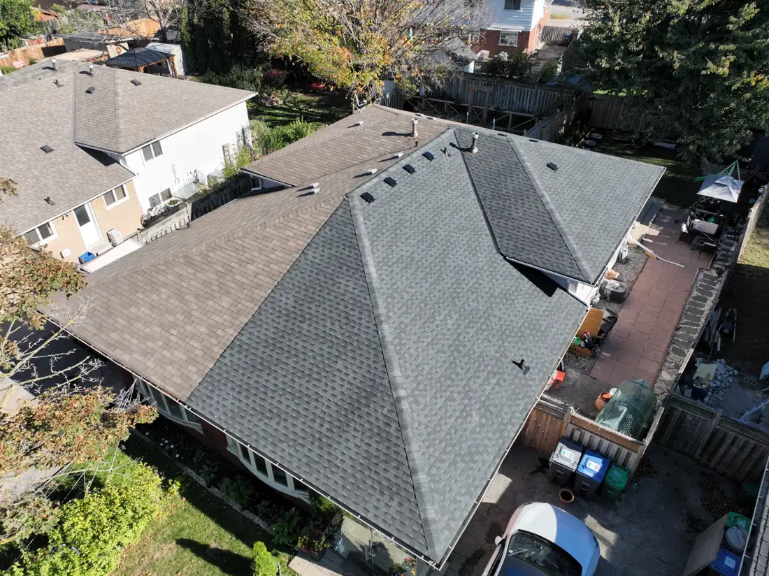 Drone view of the finished charcoal shingle roof on a detached house on Bonnymede Drive in Mississauga, with new hip caps and roof vents