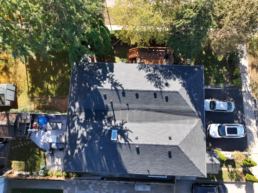 Top-down drone view of the finished Bonnymede Drive roof from the backyard side, with the driveway beside it